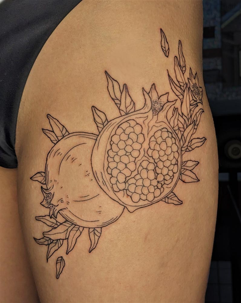 pomegranate tattoo on thigh done by lacey o'neill