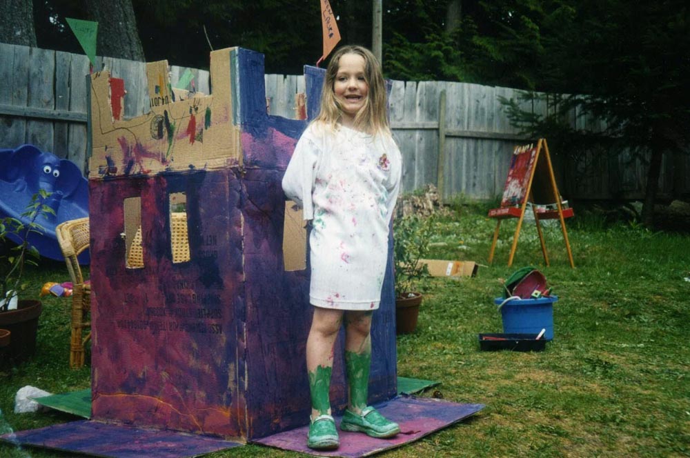 Lacey O'Neill at a young age painting a cardboard castle
