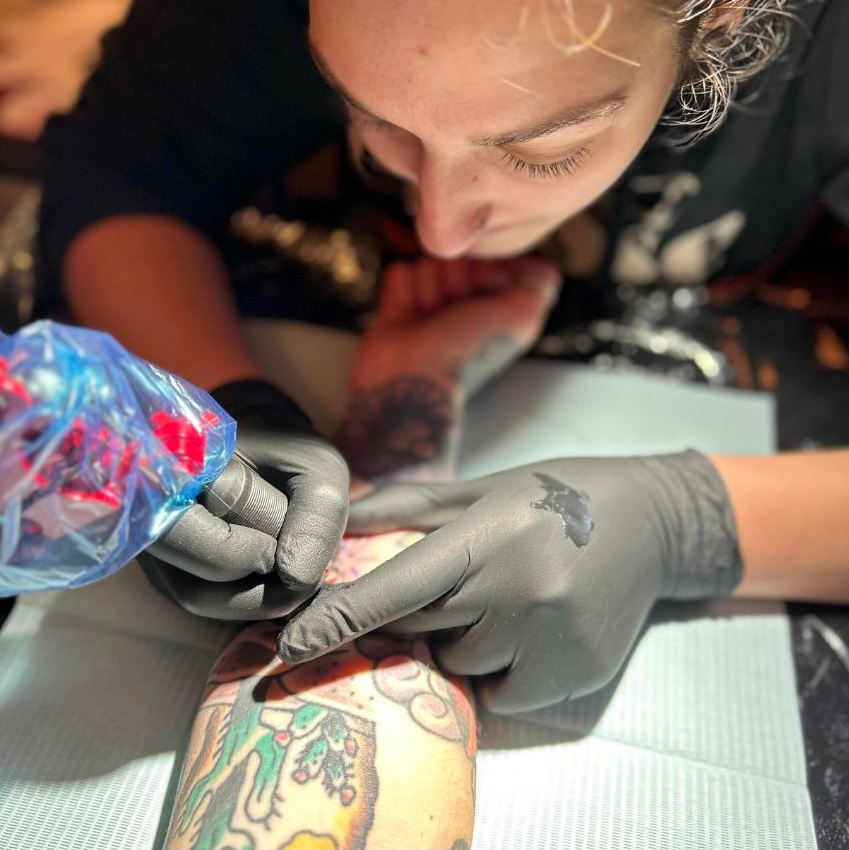 picture of lacey o'neill tattooing a forearm